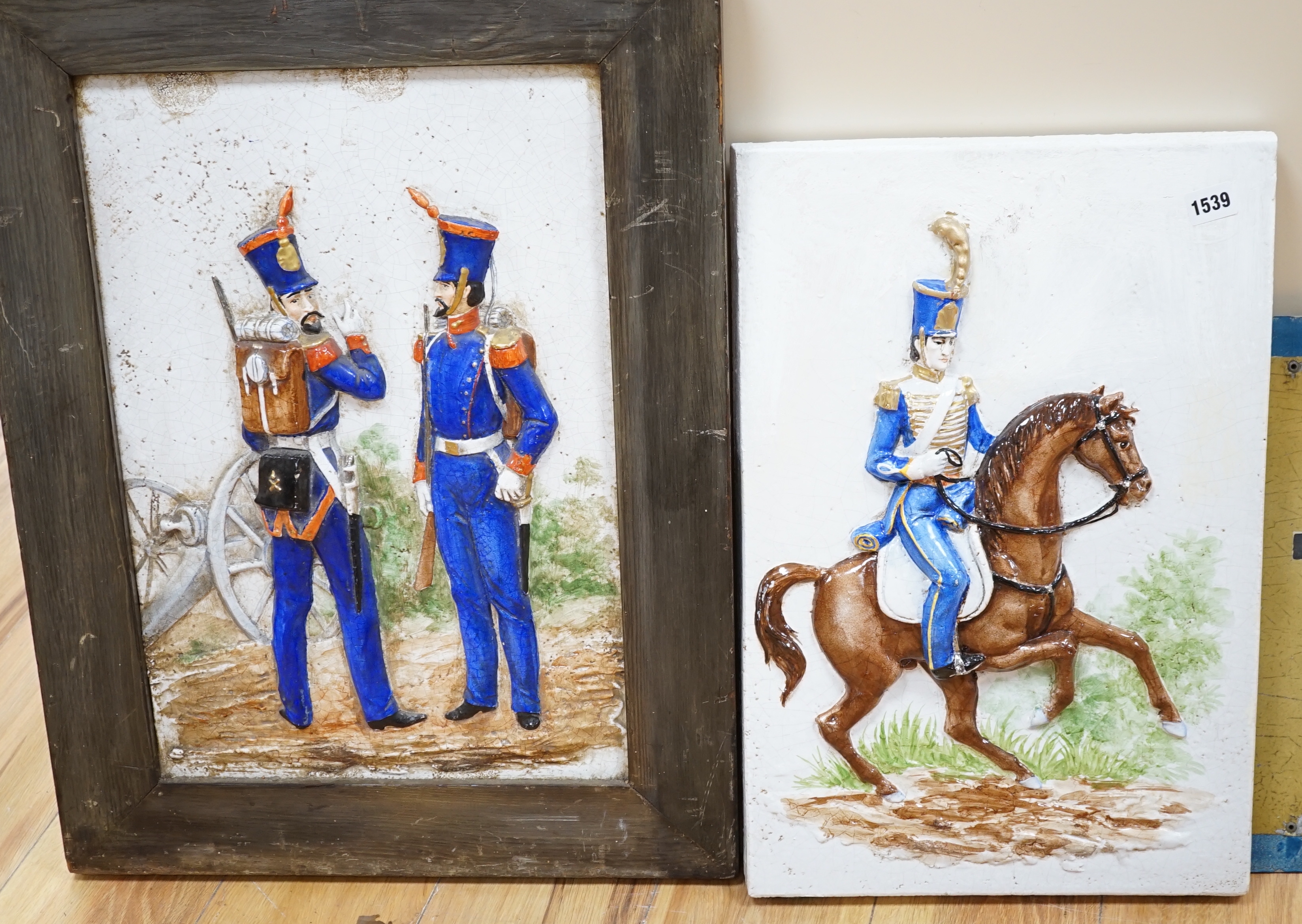 Two Continental panels painted in relief with gentleman wearing military dress, largest overall 67 x 50cm